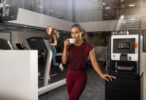 Woman drinking coffee from an Animo OptiMe X coffee machine in a gym