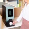 Vrouw drinkt koffie uit Animo OptiVend koffiemachine voor bedrijven